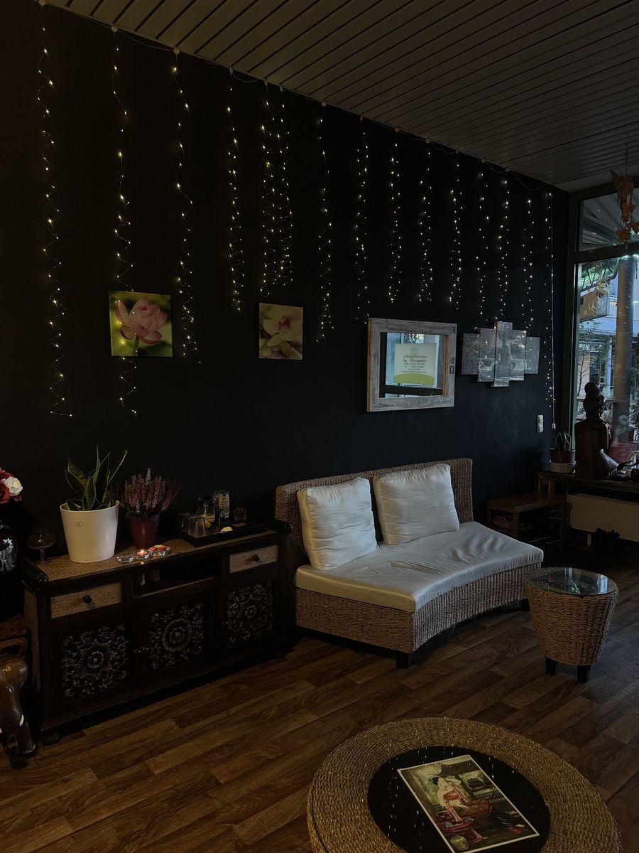 Ruhiger Lounge-Bereich mit Rattan-Sofa und handgeschnitzter Kommode